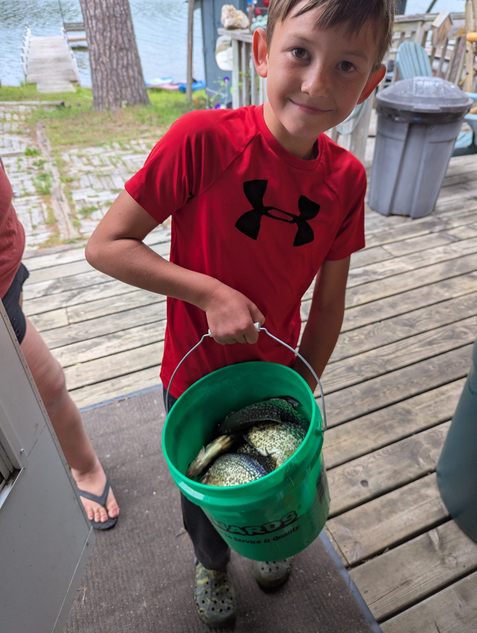 Boy with a bucket of crappie.